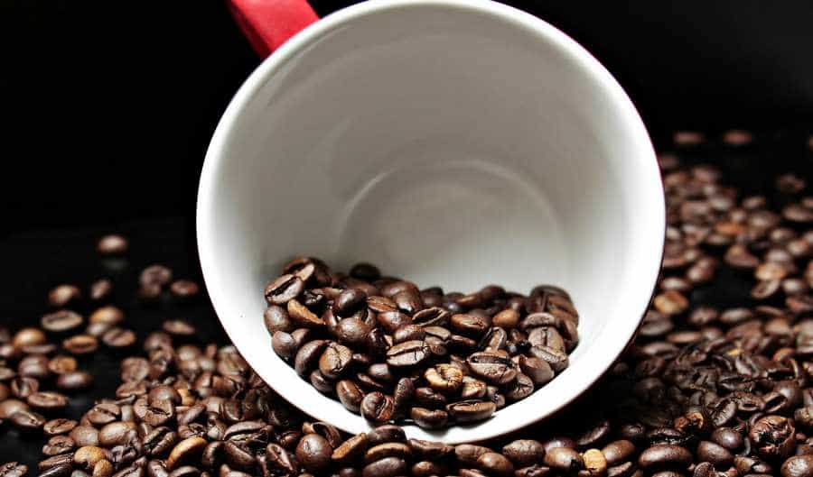 Scattered coffee beans on black background.