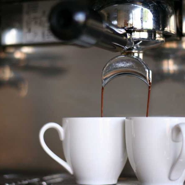 Mugs filled by espresso from espresso machine