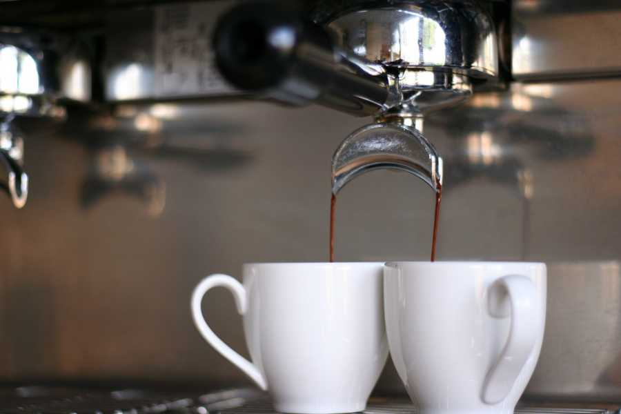 Mugs filled by espresso from espresso machine