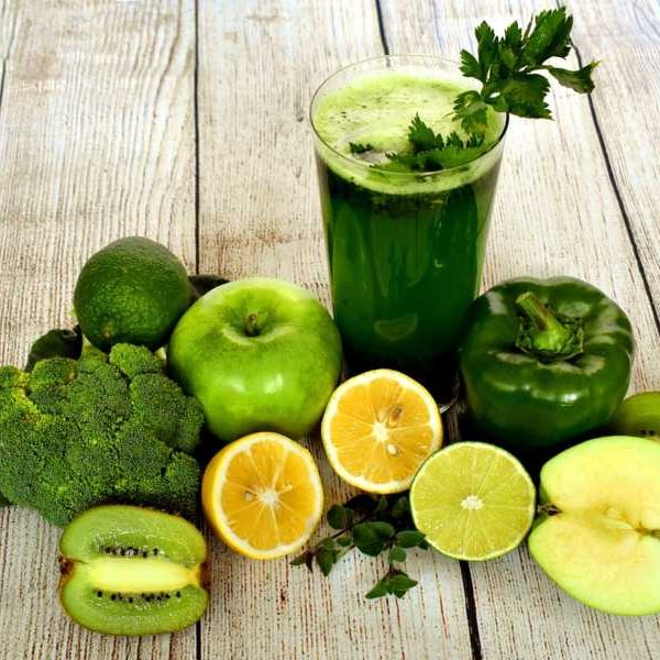 A selection of vegetarian fruits and vegetables around a green smoothie