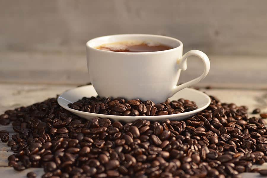 Coffee beans around a coffee cup in one of the Mochas & Javas coffee shops in Frisco TX.