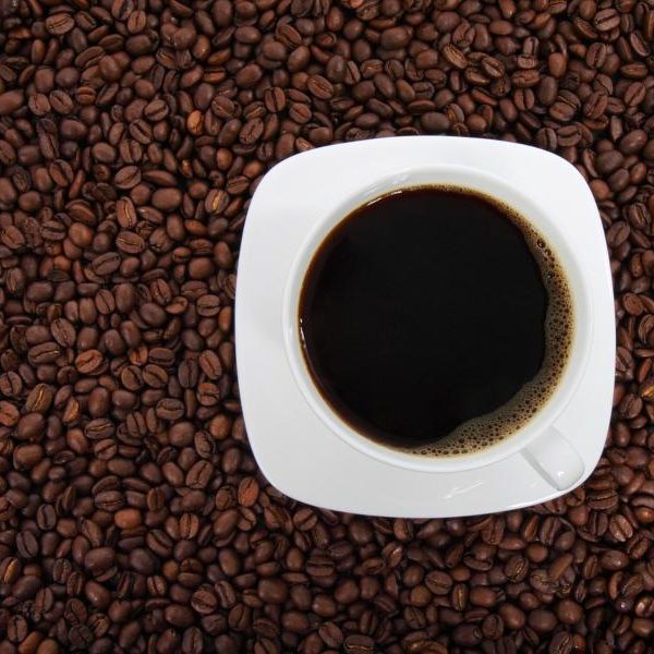 Cup of San Marcos coffee on background of coffee beans