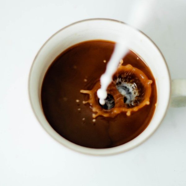 Milk being poured into coffee