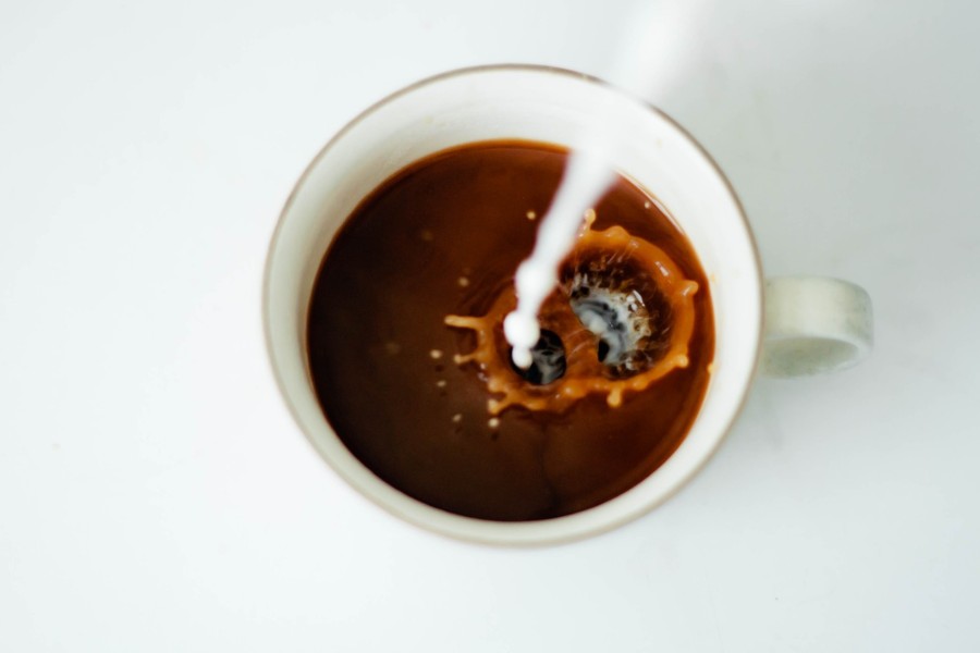 Milk being poured into coffee