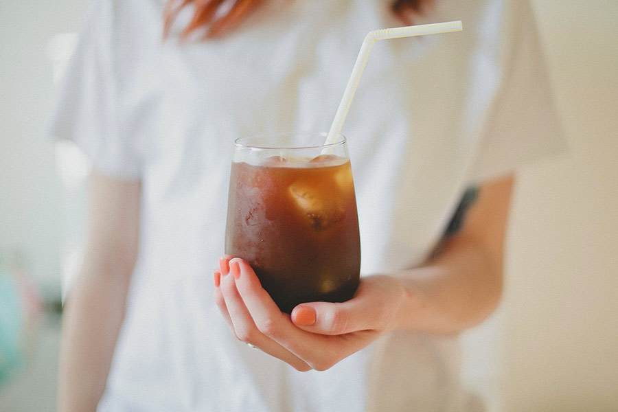 Woman holding iced coffee in San Marcos TX