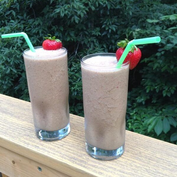 Chocolate protein smoothies on a handrail.