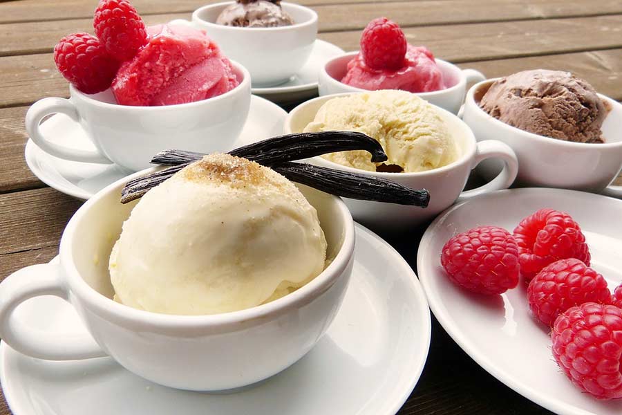 bowls of vanilla ice cream decorated with vanilla bean pods