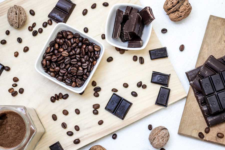 Coffee beans and chocolate bars on a cutting board