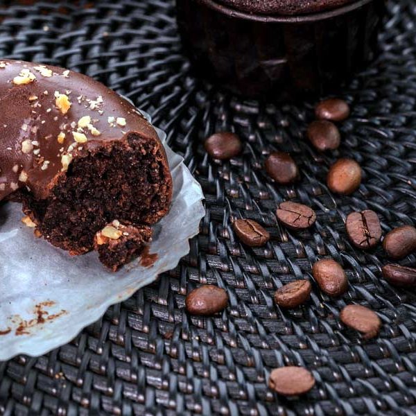 Chocolate doughnut with a coffee glaze next to coffee beans