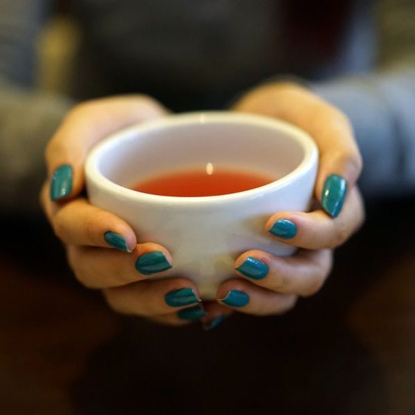 Cup of rooibos tea held in someone's hands