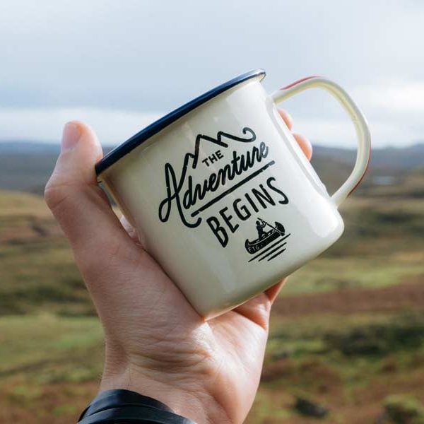 Coffee mug with the text "The Adventure Begins"