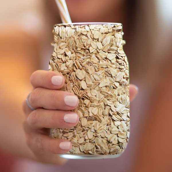 Woman holding a milk jar filled with oats