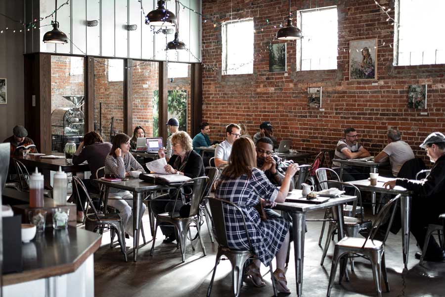 Interior photo of a bustling coffee shops in Frisco Tx with art hanging on the walls