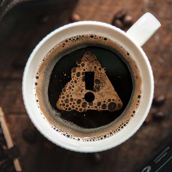 Cup of coffee with an exclamation mark made out of bubbles