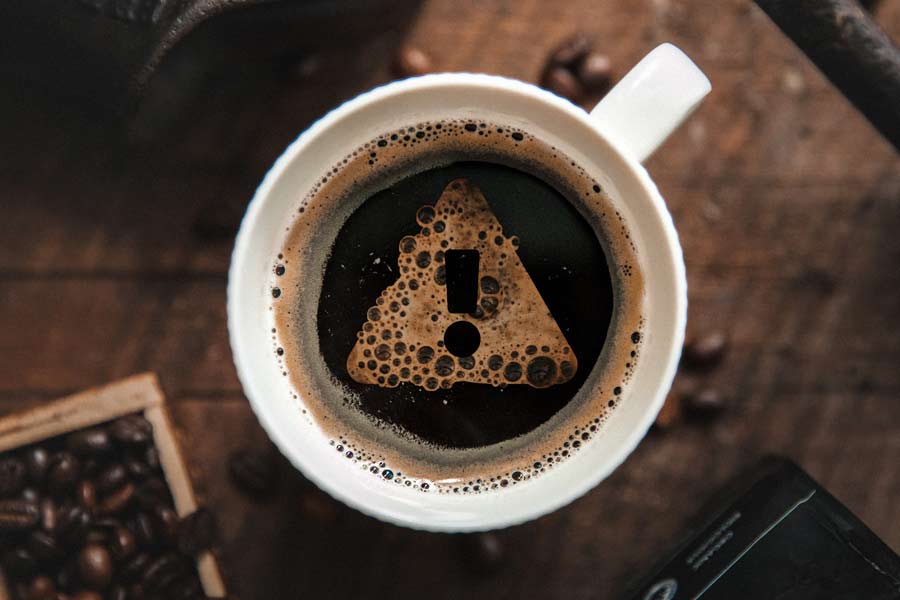 Cup of coffee with an exclamation mark made out of bubbles