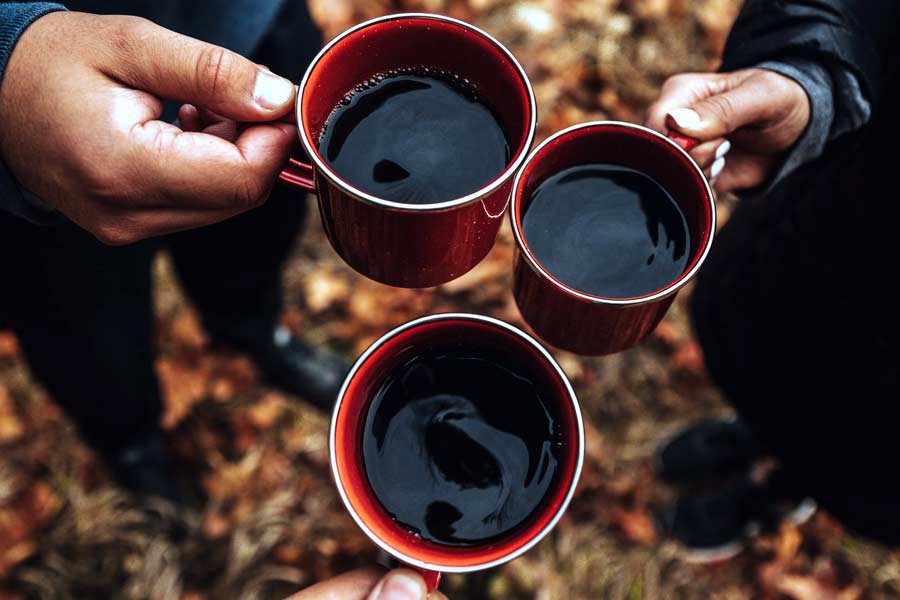 3 people toasting with coffee mugs at a coffee shop or shops in frisco tx