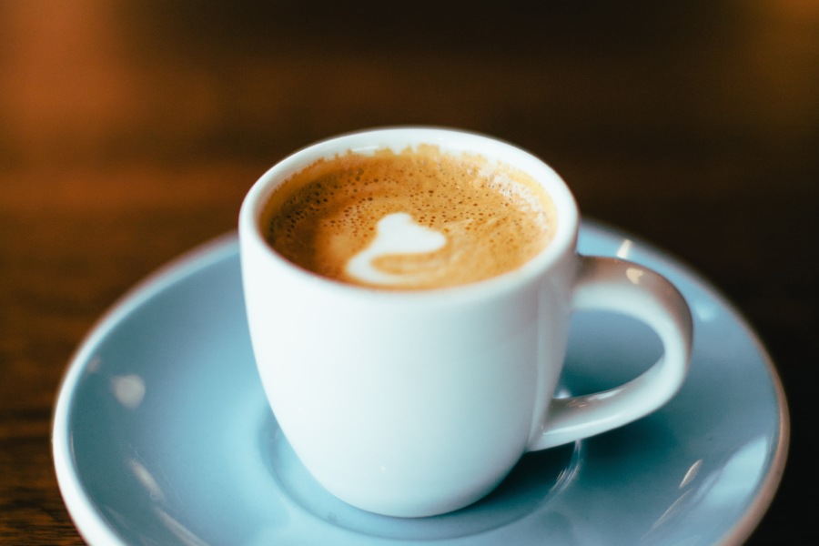 light blue coffee cup and saucer with cappuchino in it - Coffee Drive Thru Shops in Frisco, Tx