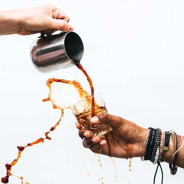 Coffee pouring into a glass and spilling out