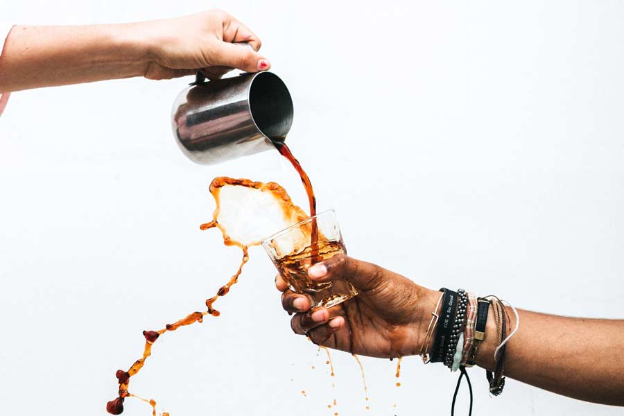 Coffee pouring into a glass and spilling out