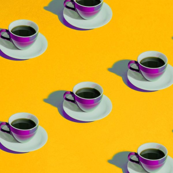 Pattern of purple San Marcos coffee cups on a yellow background