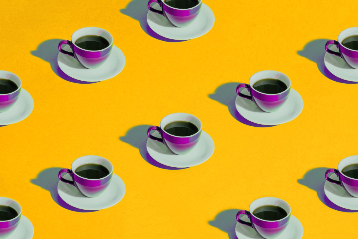 Pattern of purple San Marcos coffee cups on a yellow background