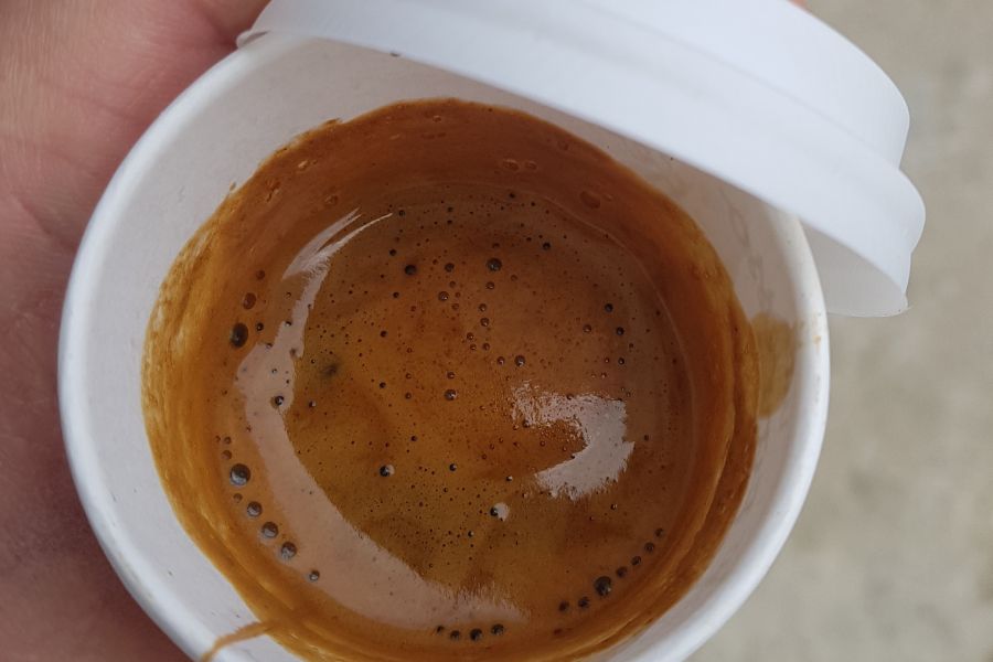 Close up of a hand holding a paper coffee cup.