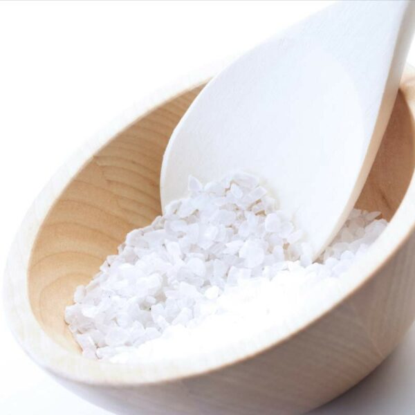 Zoomed in shot of a wooden bowl full of coarse grain salt