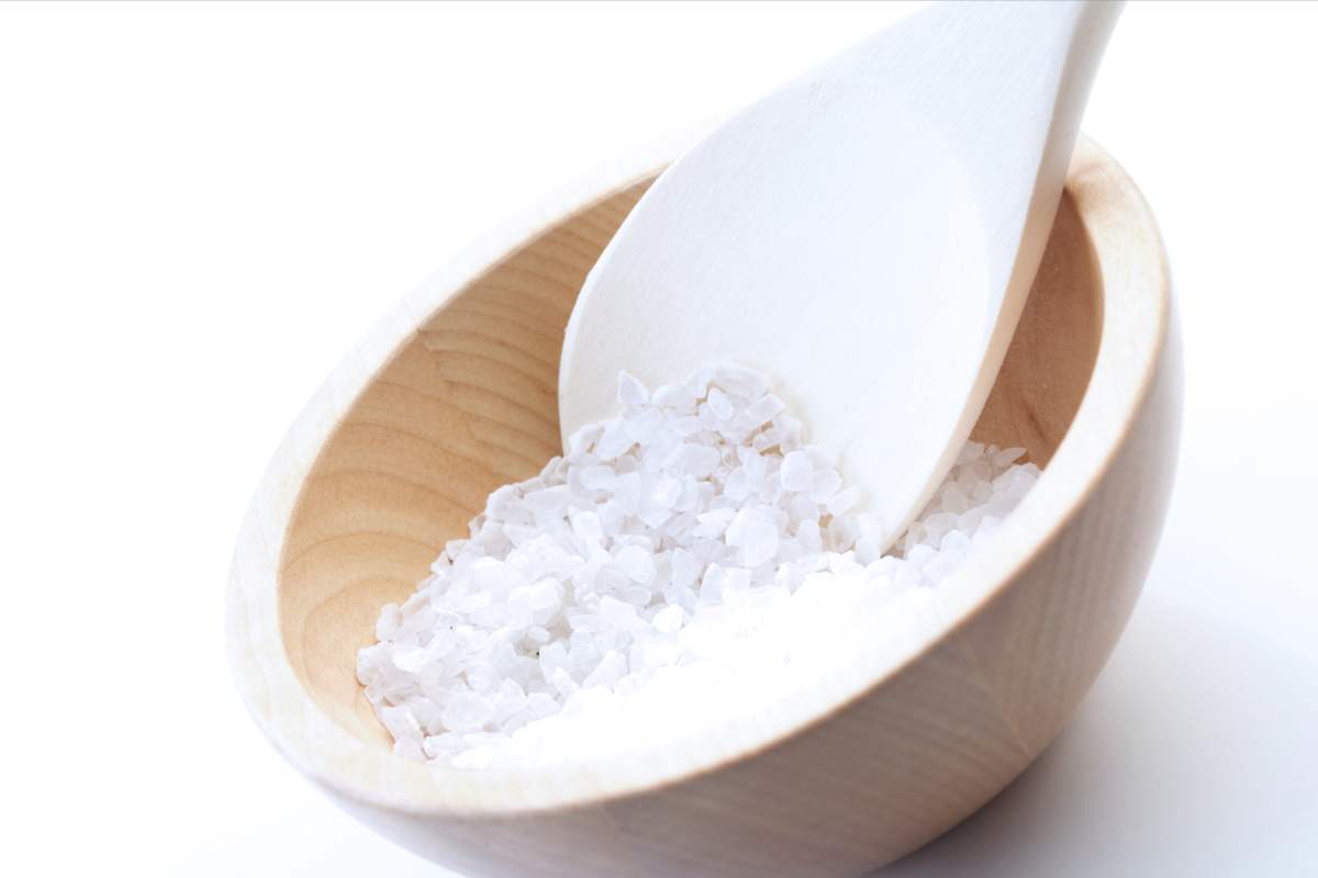 Zoomed in shot of a wooden bowl full of coarse grain salt