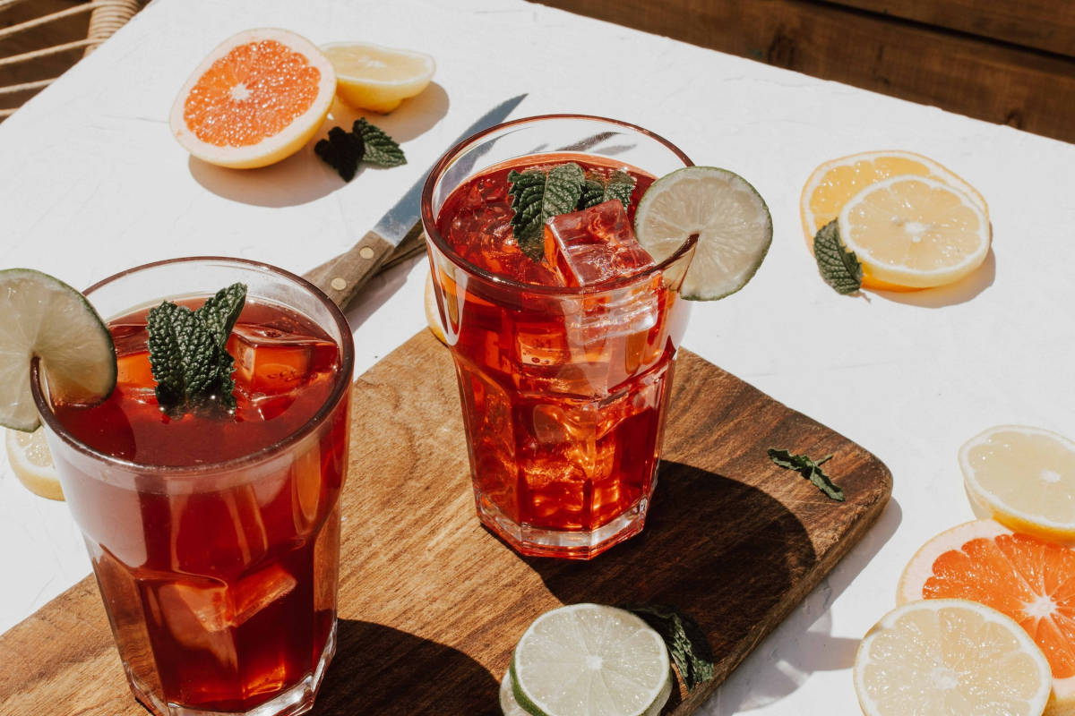 2 refreshing glasses of iced kombucha with fruit slices on a tasting board that you can order from drive thru in Frisco TX