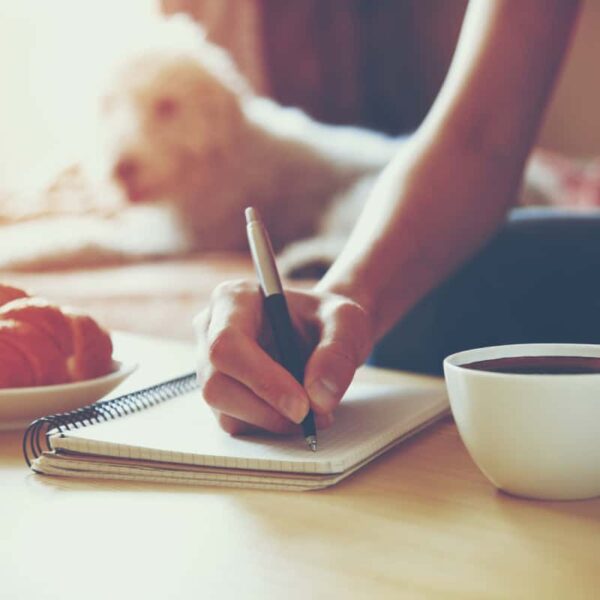 a person journaling while drinking coffee in San Marcos TX in the morning.