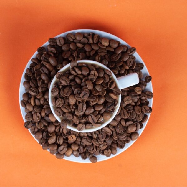 Coffee Mug and Saucer Overflowing with Coffee Beans: Representing the High-Quality Coffee Beans Used by Coffee Shops to Prepare Beverages for Customers in San Marcos, TX