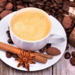 a cup of coffee with cinnamon, cocoa and other spices