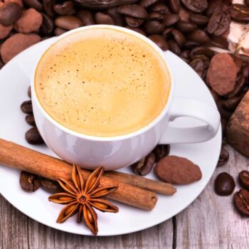 a cup of coffee with cinnamon, cocoa and other spices