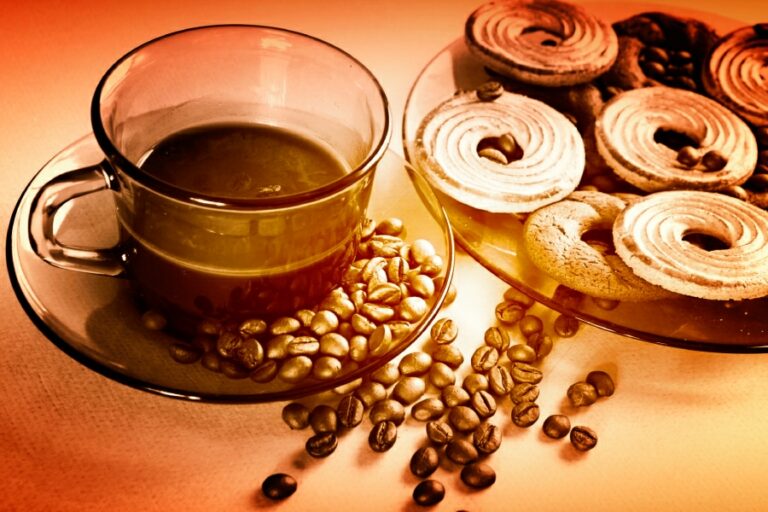 An image of a cup of coffee with a plate of sweet treats