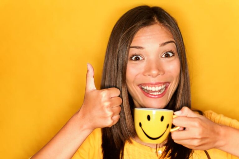An image showing a woman smiling after having a morning cup coffee