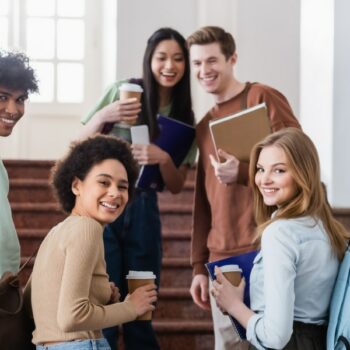 An image showing a group of college students enjoying a good talk while drinking their morning coffee