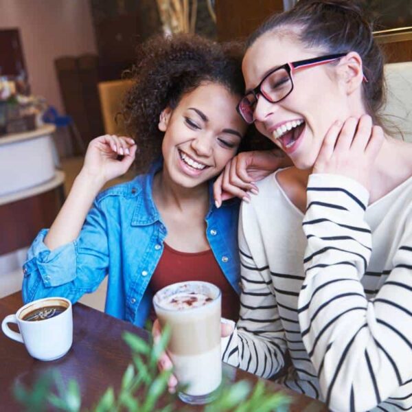 two girlfriends having a coffee and laughing