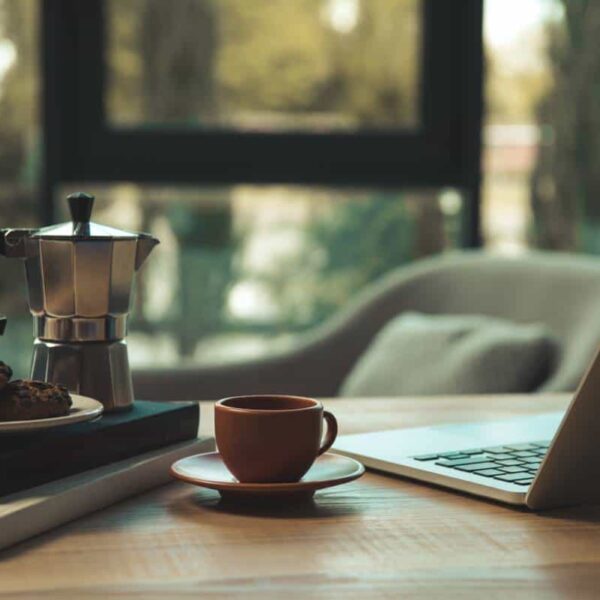 Cozy morning scene at Frisco cafe with cookies, laptop, and coffee on table