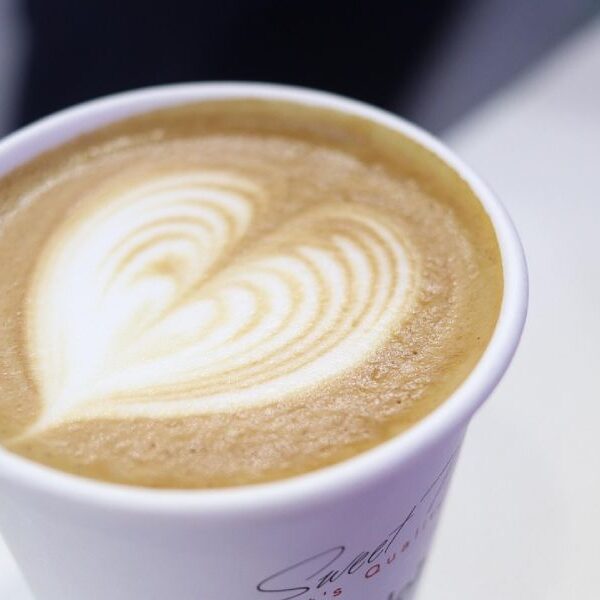 A close up of a latte with a heart design in it.