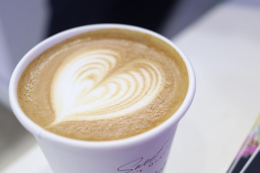 A close up of a latte with a heart design in it.