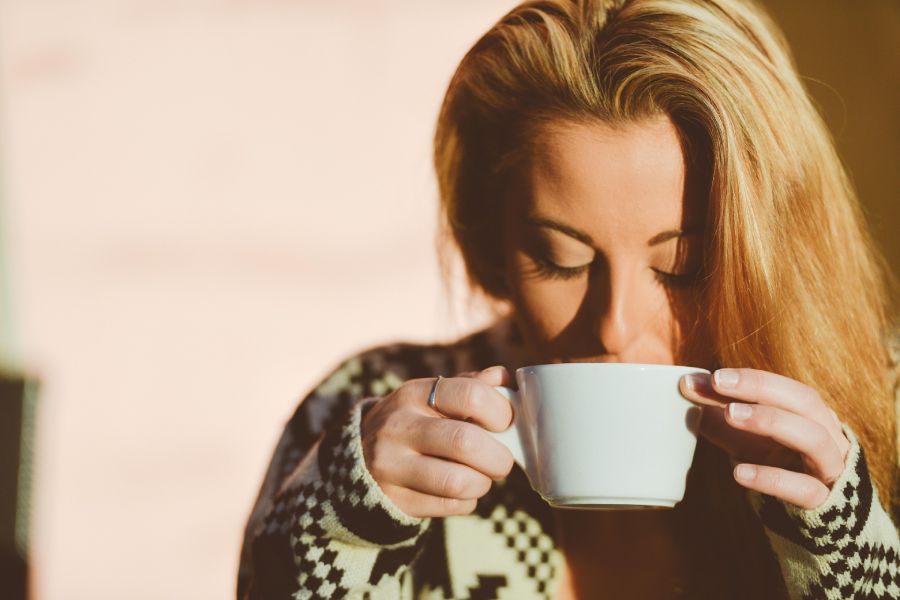 A woman drinking a cup of coffee.
