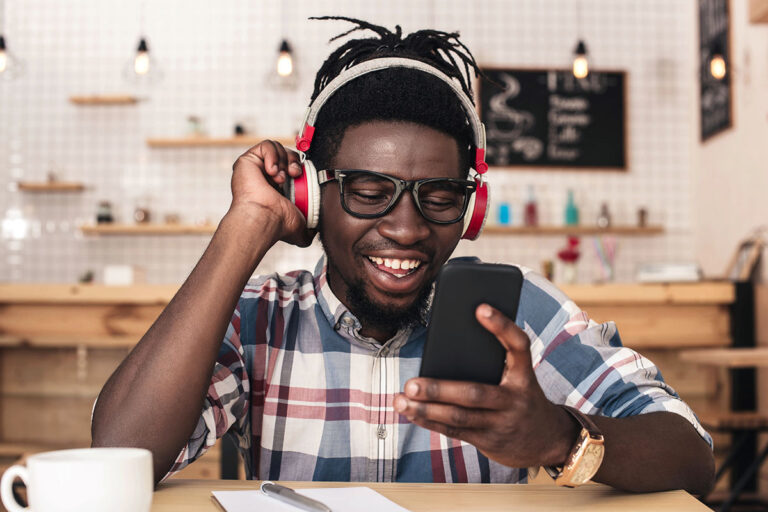 A man wearing headphones enjoying music at a San Marcos coffee shop.